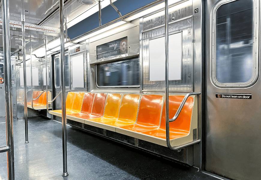 Inside view of empty New York City subway train with orange and yellow seats